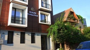 Un hotel con fachada moderna, balcones y un letrero que indica que es el Eleon Boutique Hotel.
