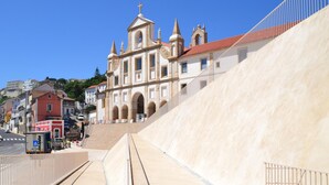 A large, modern building with a prominent entrance and a steep ramp leading up to it. - Archisuites (Coimbra)