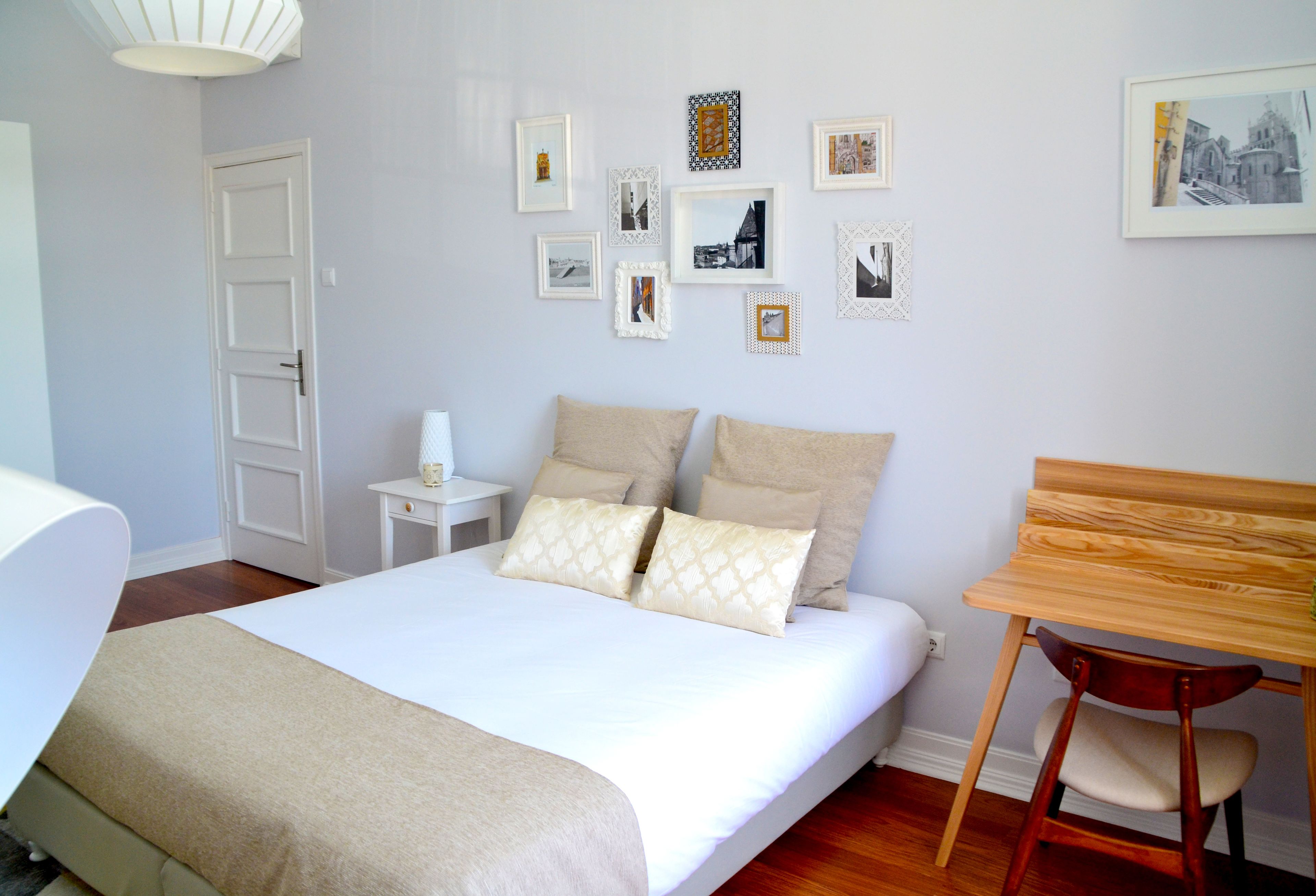 Une chambre à coucher bien rangée, avec un lit, une table de chevet et une chaise en bois.