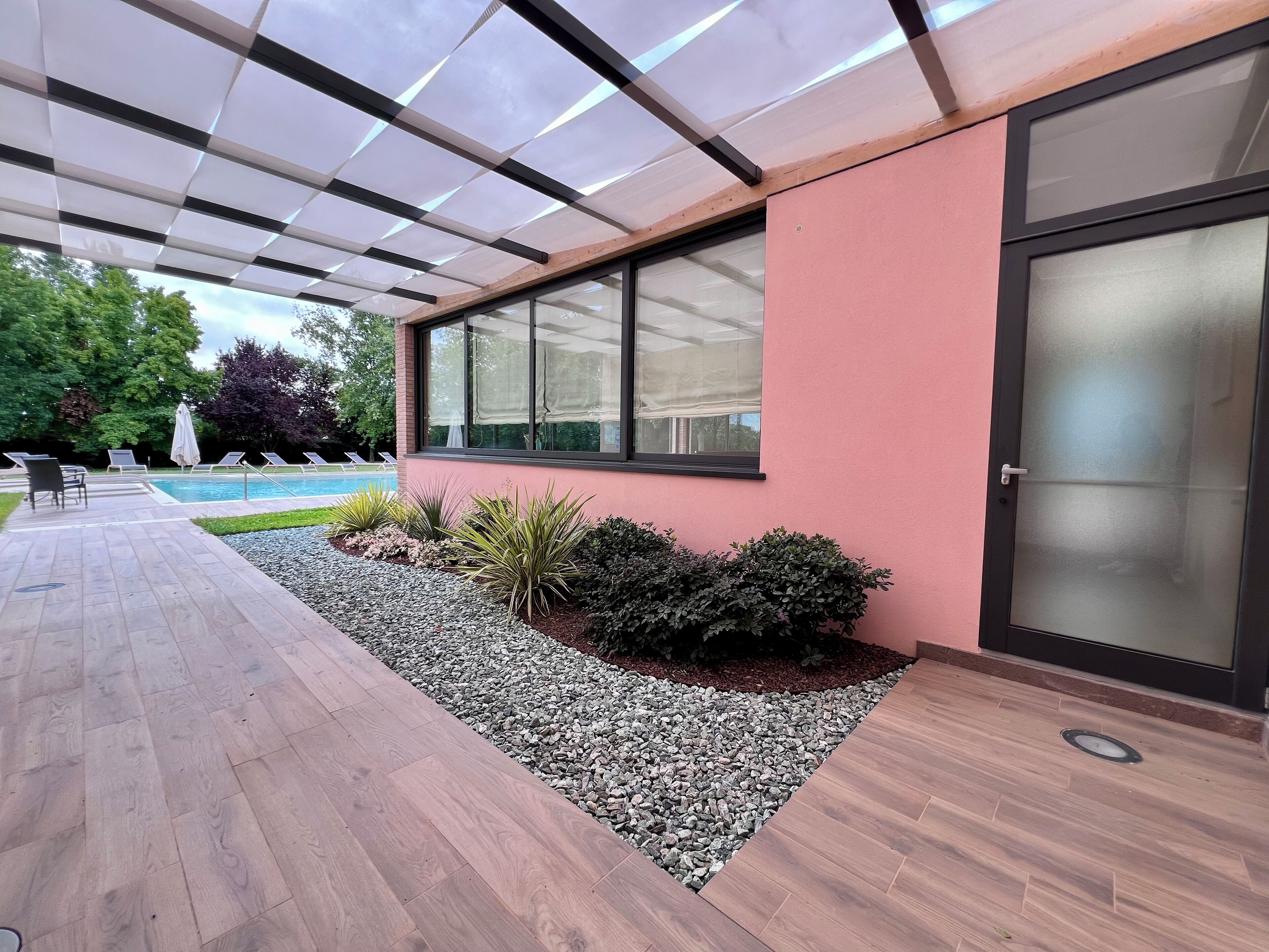 Ein modernes Gebäude mit Pool, Sitzgelegenheiten im Freien und einer überdachten Terrasse.
