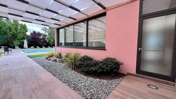 Ein modernes Gebäude mit Pool, Sitzgelegenheiten im Freien und einer überdachten Terrasse.