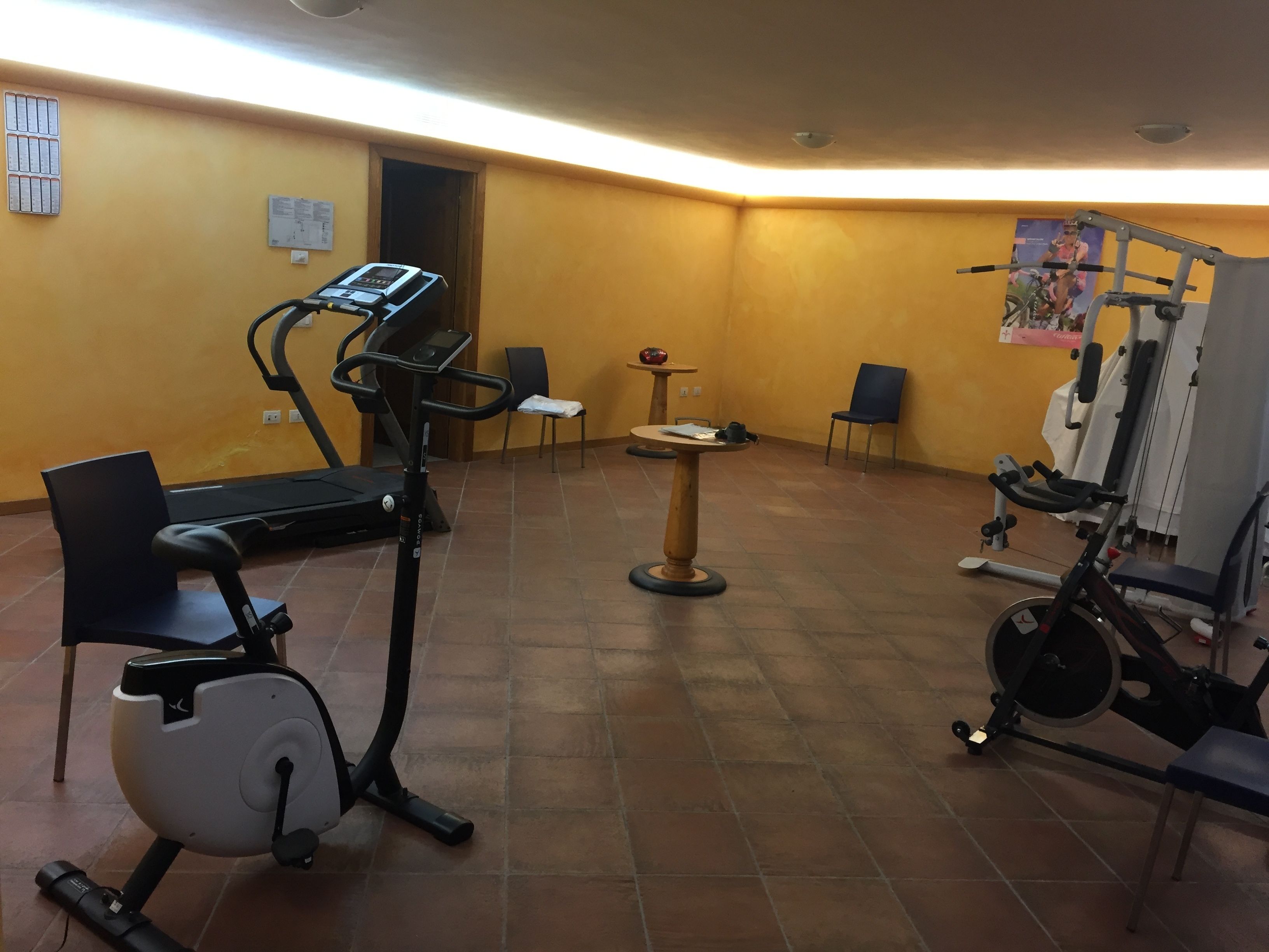 A gym with exercise equipment including a treadmill, stationary bike, and weight machines.