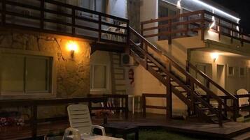 Un immeuble à plusieurs étages doté d’une terrasse et d’un escalier menant à un niveau supérieur.