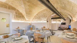 A dining area with hexagonal tiled flooring, tables set with plates and glasses, and chairs. - Boutique Hotel Sant Roc & Spa (Mahón)