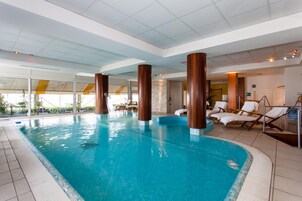 Una piscina techada, sillones reclinables de piscina