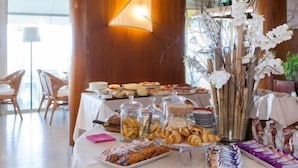 Een buffet met diverse gerechten en een decoratieve orchidee-bloemstelling.