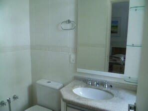 Ein Badezimmer mit Waschbecken, Spiegel und Toilette.