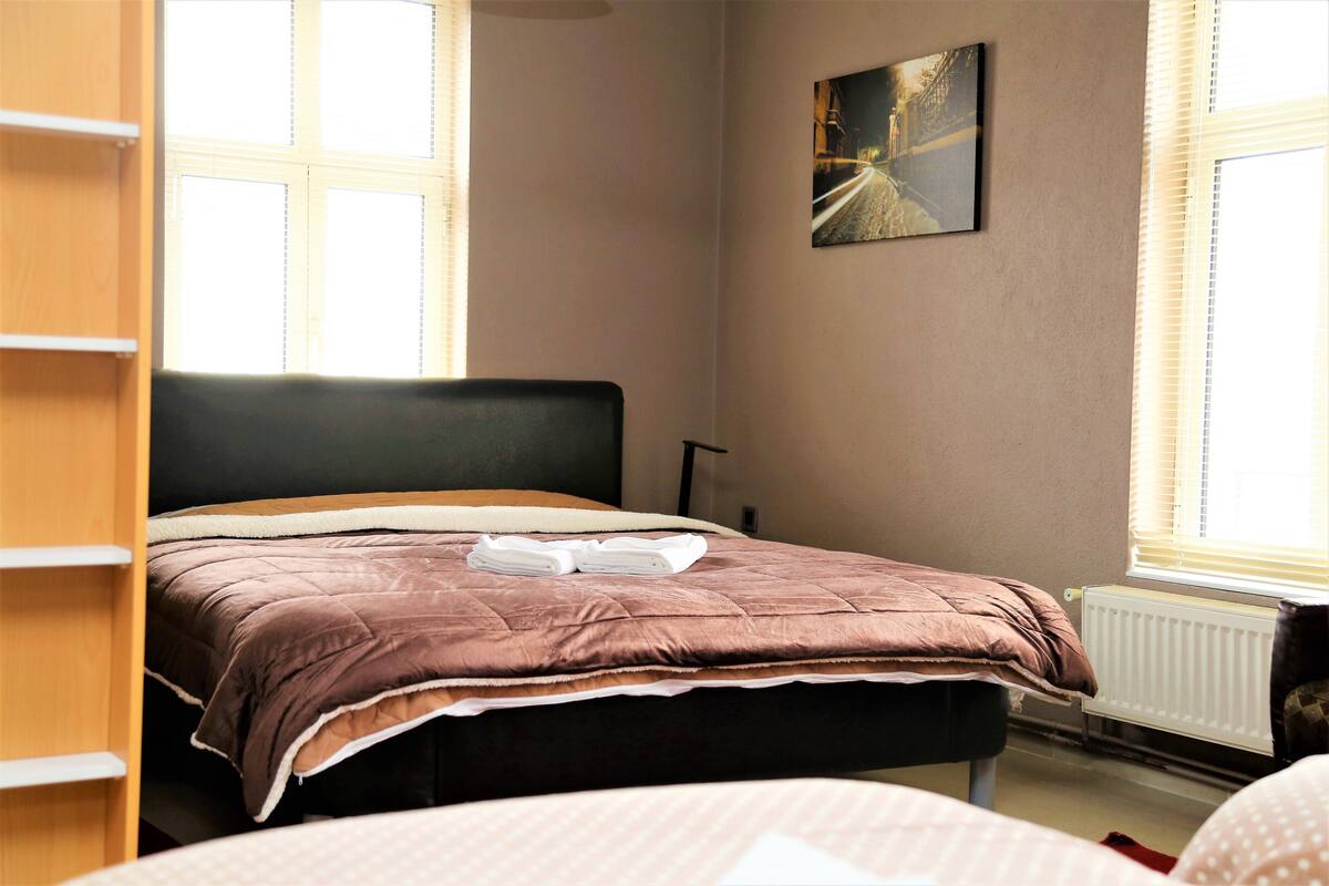 Un dormitorio con una cama, un radiador y una ventana.