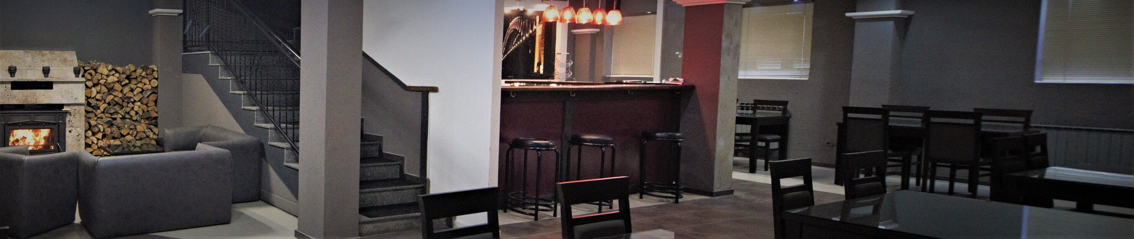 En bar med pejs, siddepladser og trappe.