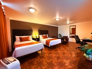 A hotel room with two beds, a desk, a chair, a mirror, and a small plant. - Suites Teziutlan (Teziutlan)