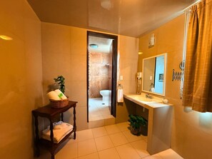 A bathroom with a wooden vanity, a sink, a mirror, and a potted plant. - Suites Teziutlan (Teziutlan)