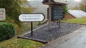 Un letrero que dice 'Village vacances de Membre "LES HOCHETS"' con una estructura de madera y buzón.