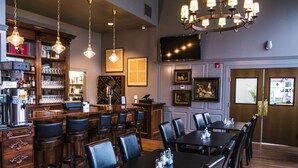 A restaurant with wooden furniture, a bar area, and a television mounted on the wall. - The Meadows Hotel (Fulton)