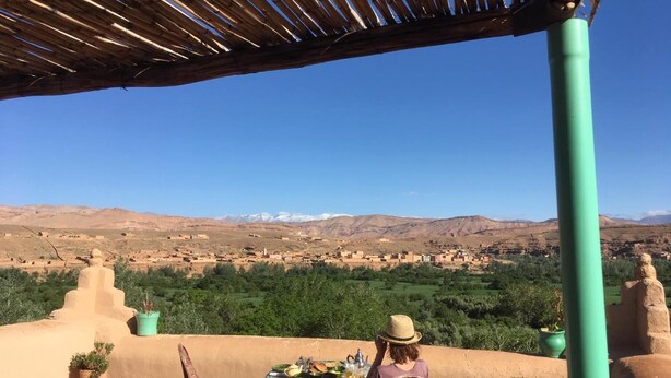 Une terrasse avec une table et des chaises, offrant une vue sur un paysage montagneux.
