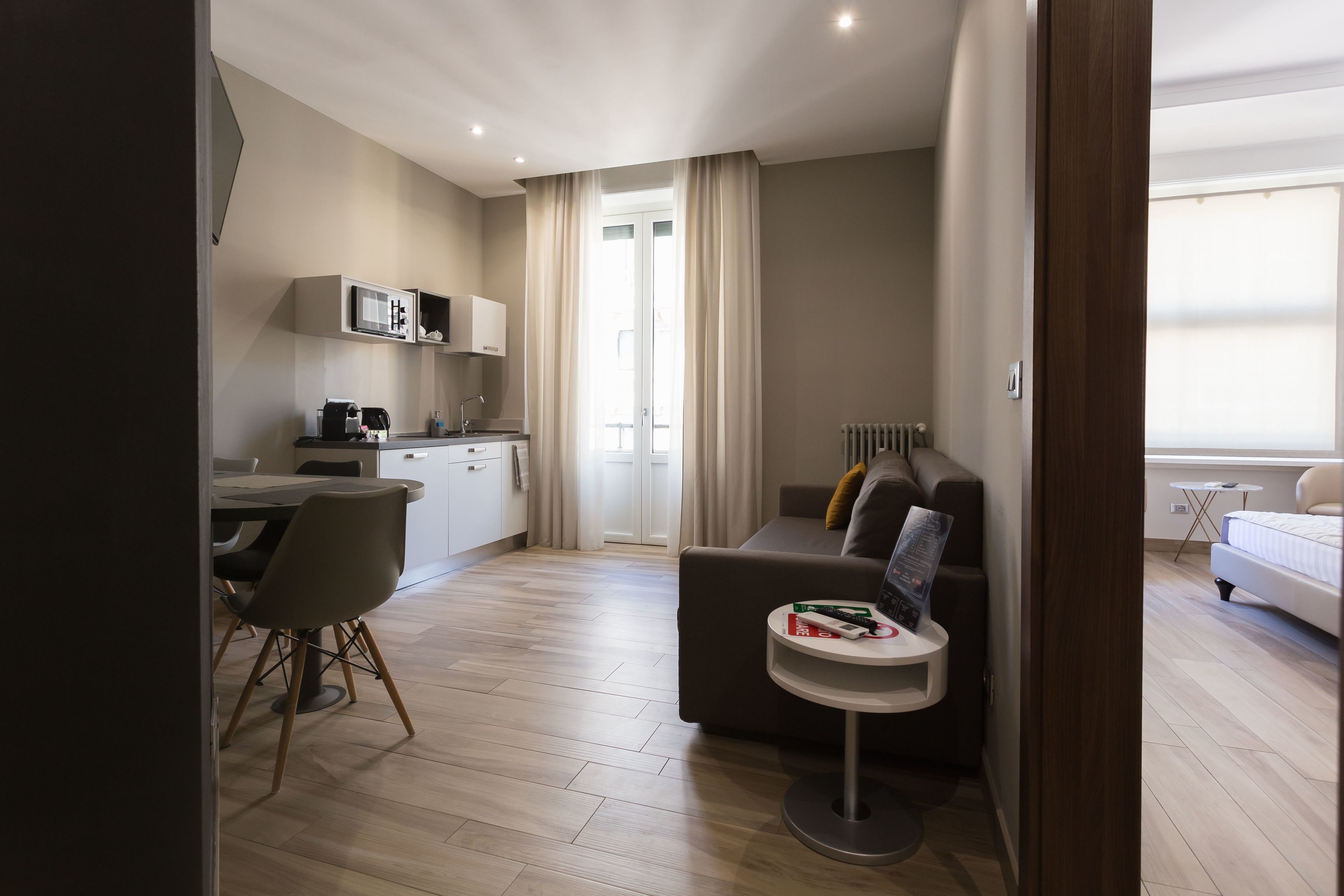 Eine moderne Wohnung mit Essbereich, Küchenzeile und Wohnzimmer mit Sofa und kleinem Beistelltisch.