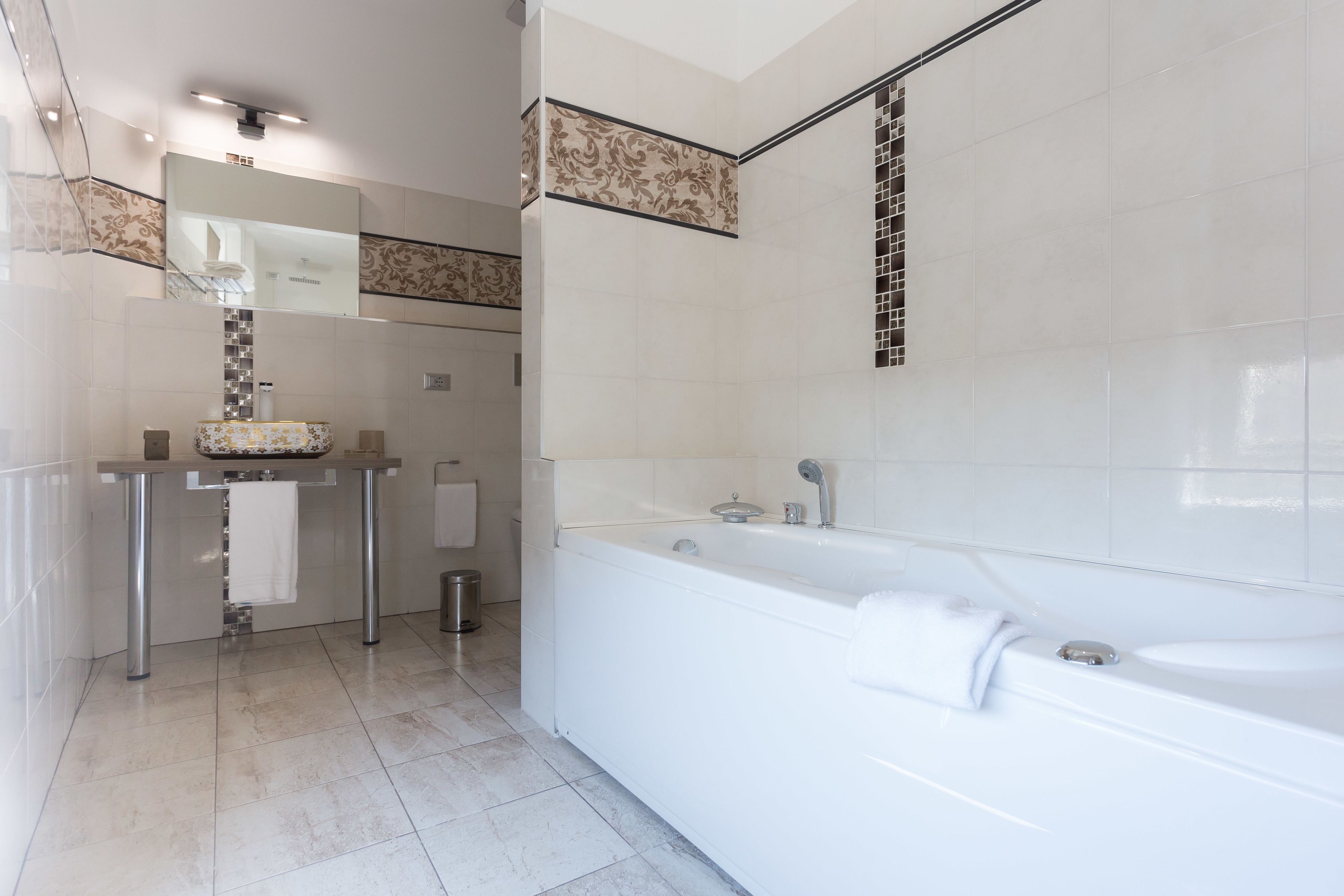 Un baño moderno con bañera, tocador con espejo y zona de ducha.