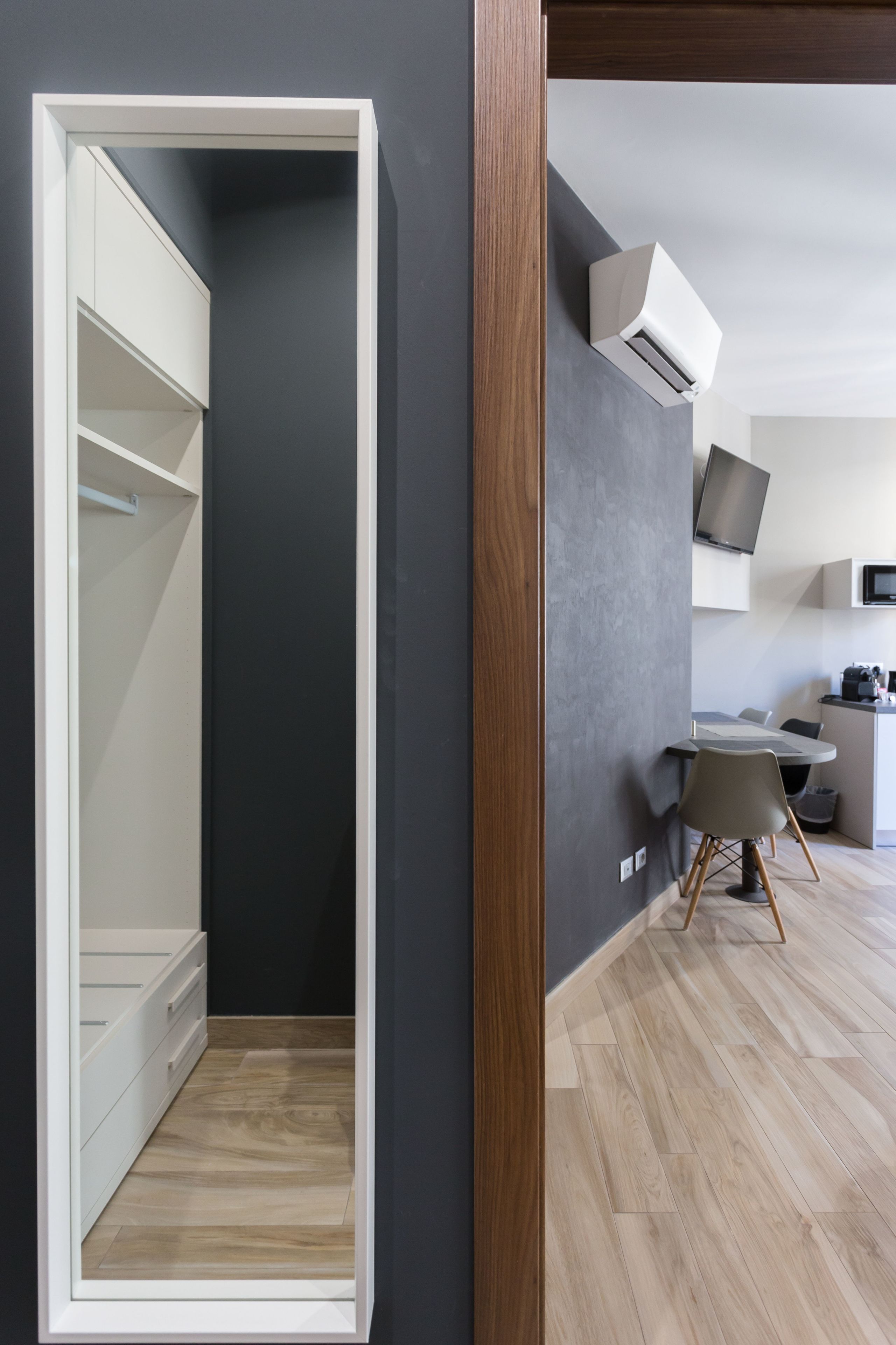 Een moderne keuken met een flatscreen televisie, een ingebouwde airconditioning en een eethoek met tafel en stoelen.