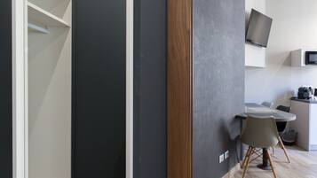 Een moderne keuken met een flatscreen televisie, een ingebouwde airconditioning en een eethoek met tafel en stoelen.