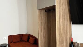 Une pièce moderne comprenant un canapé, une table à manger et un téléviseur fixé au mur.