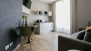 Un salon moderne avec un canapé et un coin repas comprenant une table et des chaises.