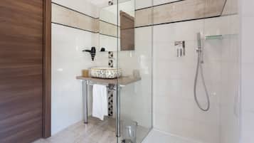 Une salle de bain moderne avec une douche à parois de verre, un meuble-lavabo en bois et un grand miroir.