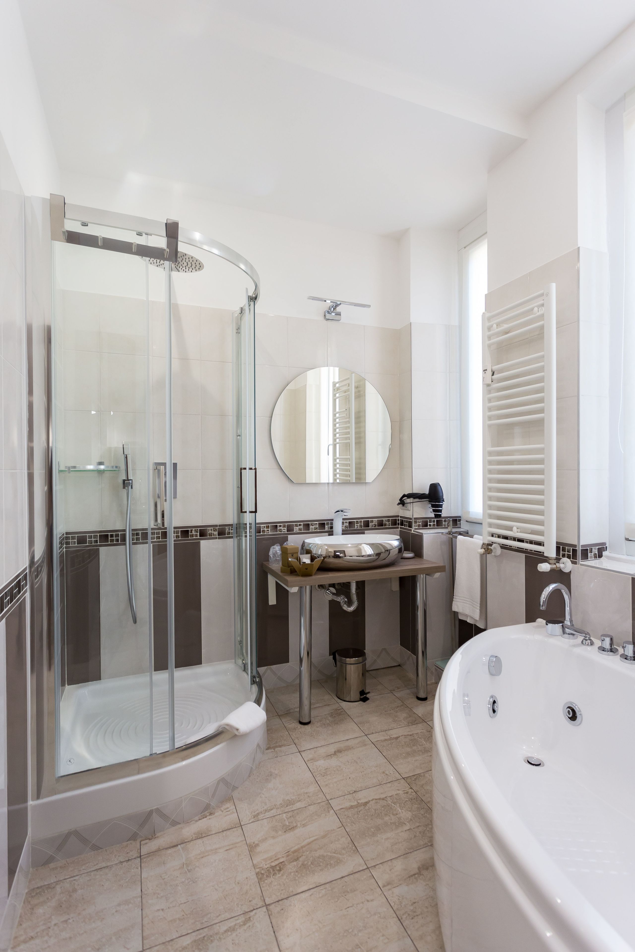 Une salle de bain moderne avec une douche à parois de verre, une baignoire sur pieds et un meuble-lavabo avec un miroir.