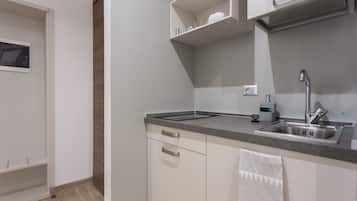 A modern kitchen with white cabinets, a stainless steel sink, and a countertop.