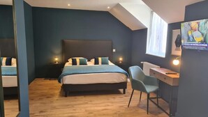 Une chambre à coucher avec un lit, des tables de chevet, un bureau et une chaise.