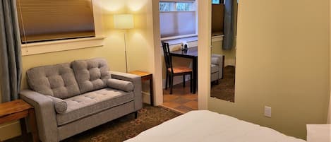 Una habitación de hotel con cama, sofá, escritorio y silla.