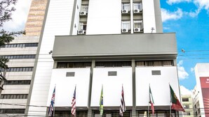 A tall hotel with multiple floors, a covered entrance, and several flags. - Hotel Dan Inn São José do Rio Preto By Nacional Inn  (São José do Rio Preto)
