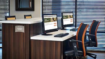 Un mostrador de recepción con dos monitores, un teclado y sillas de oficina en un entorno de oficina moderno.