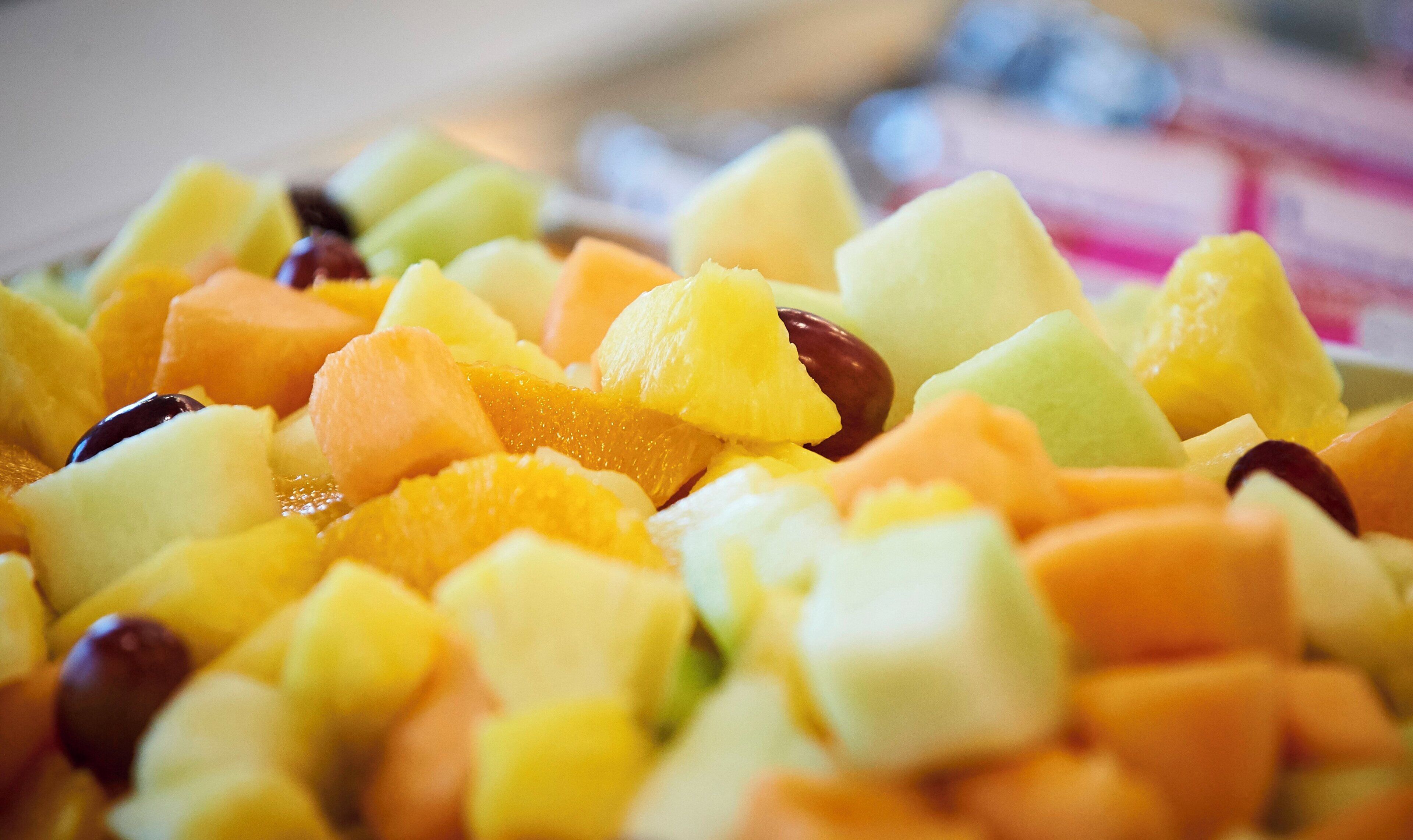 A close-up of a fruit salad with various types of fruit.