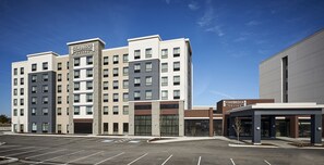 Een Staybridge Suites hotel met een modern design, meerdere verdiepingen en een parkeerplaats ervoor.
