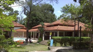 A building with a tiled roof, a swimming pool, and a well-maintained lawn. - Chaya Resort (Krabi)