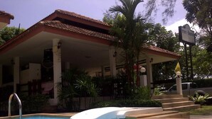 A swimming pool with a hot tub, a covered patio area, and a vehicle parked nearby. - Chaya Resort (Krabi)