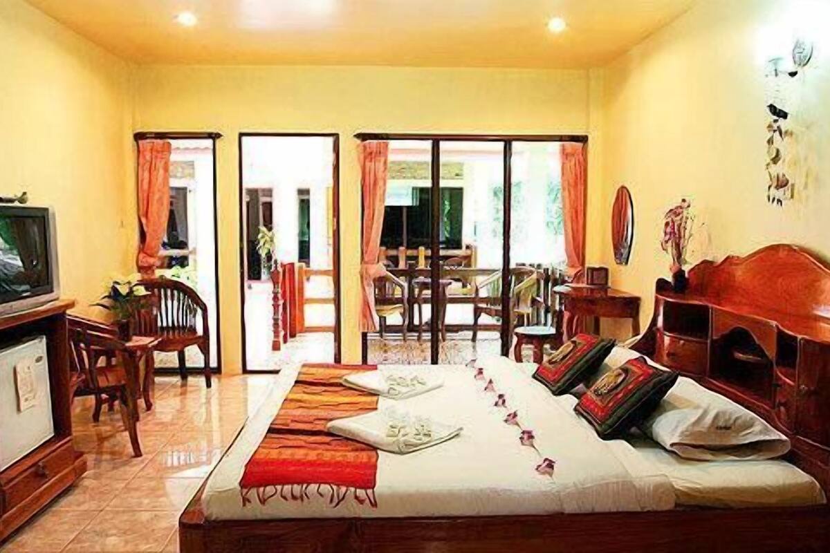 A hotel room with a bed, a TV, a desk, and a chair.