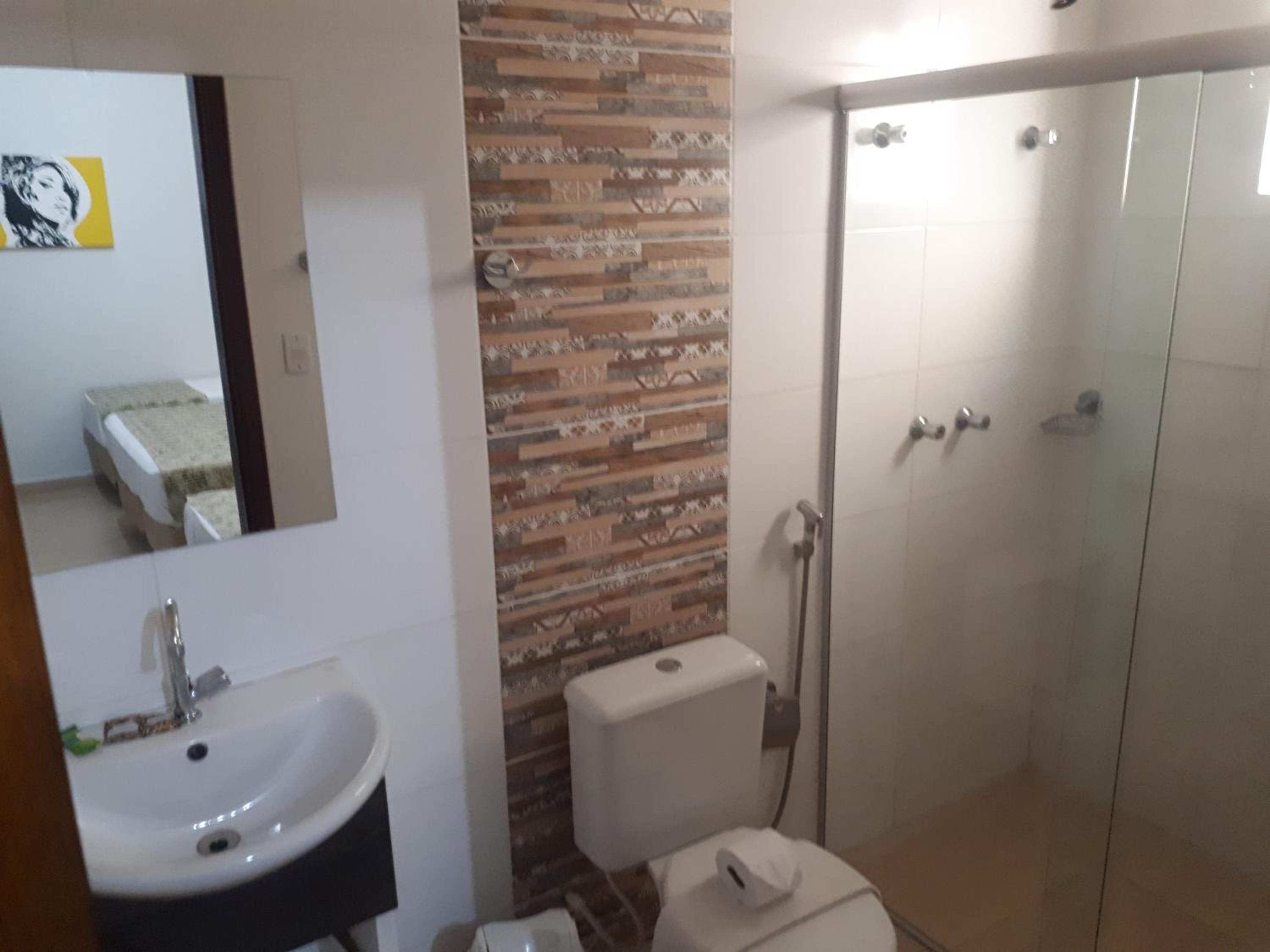 A bathroom with a sink, toilet, and shower.