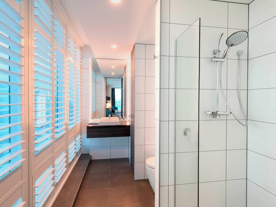 A modern bathroom with a shower, toilet, and sink.