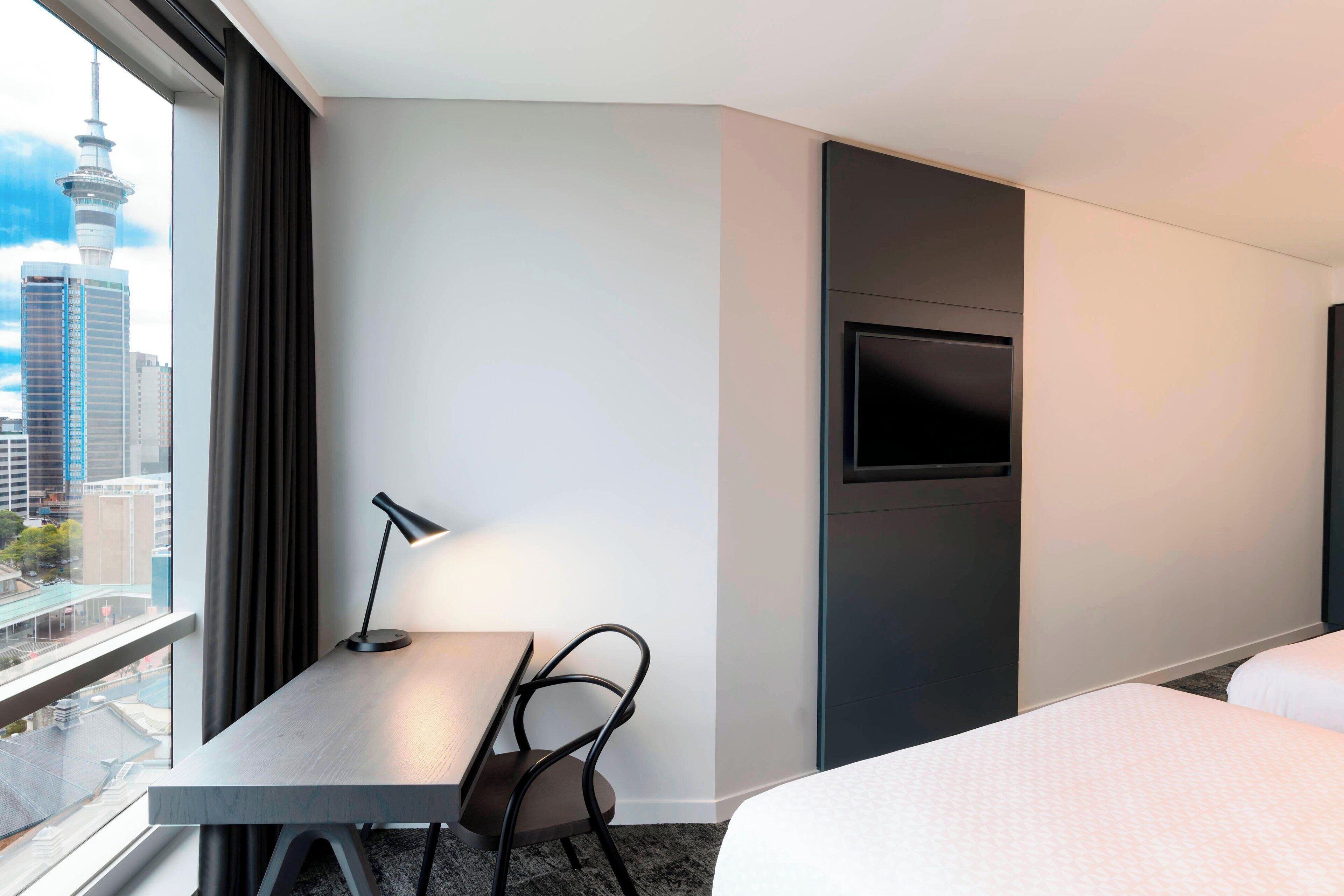 Una habitación de hotel con escritorio, silla y cama.