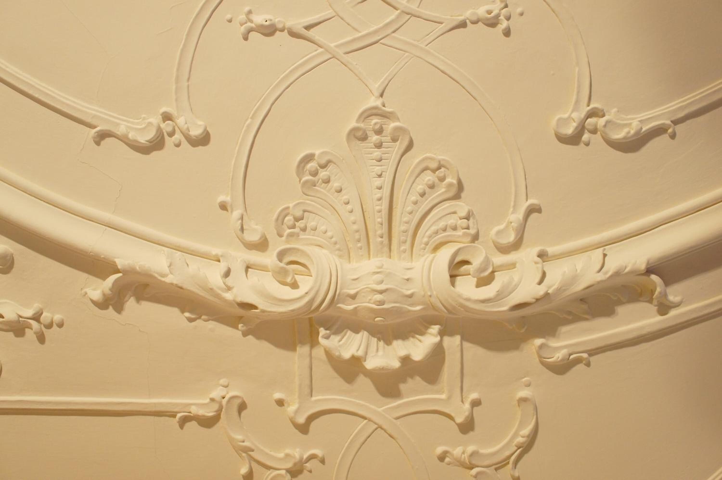 Nahaufnahme von aufwändiger architektonischer Dekoration mit filigranen Schnitzereien und Zierelementen.