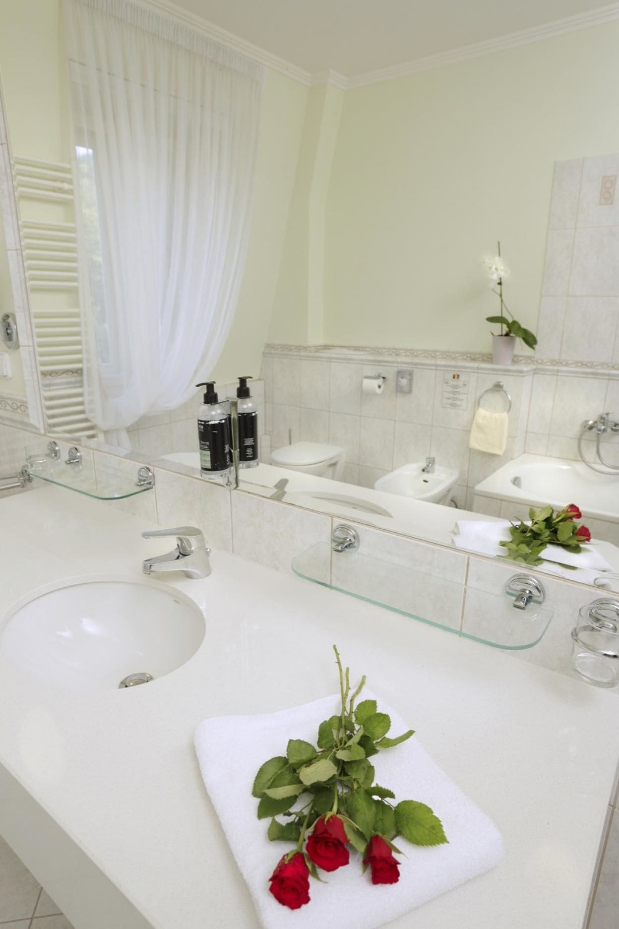Un baño moderno con un espejo grande, dos lavamanos y un box de ducha de cristal.