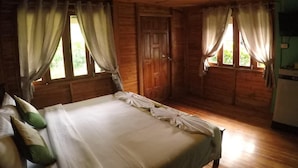 A wooden room with a bed, curtains, and a door. - Lanta Smile Beach At Klong Dao (Ko Lanta)