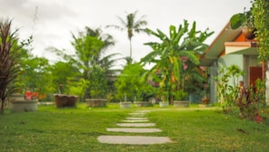 A pathway leading to a building surrounded by lush greenery and palm trees. - Lanta Smile Beach At Klong Dao (Ko Lanta)
