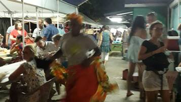 Evento ao ar livre com tendas, pessoas e mesas.