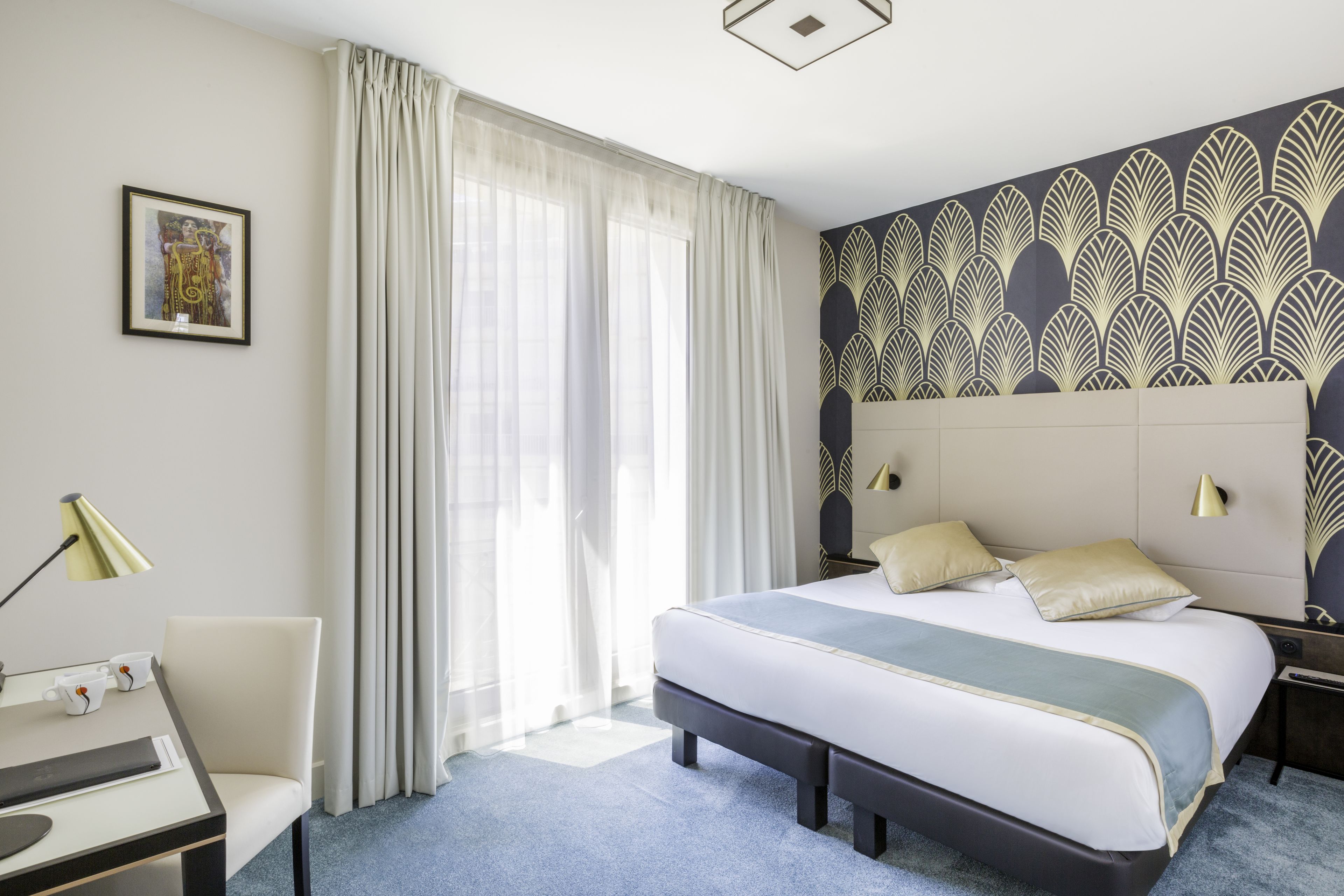 A modern hotel room with a large bed, a desk, and a chair.