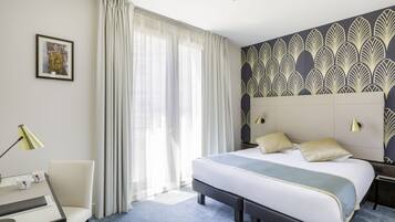 Una habitación de hotel moderna con una cama grande, un escritorio y una silla.