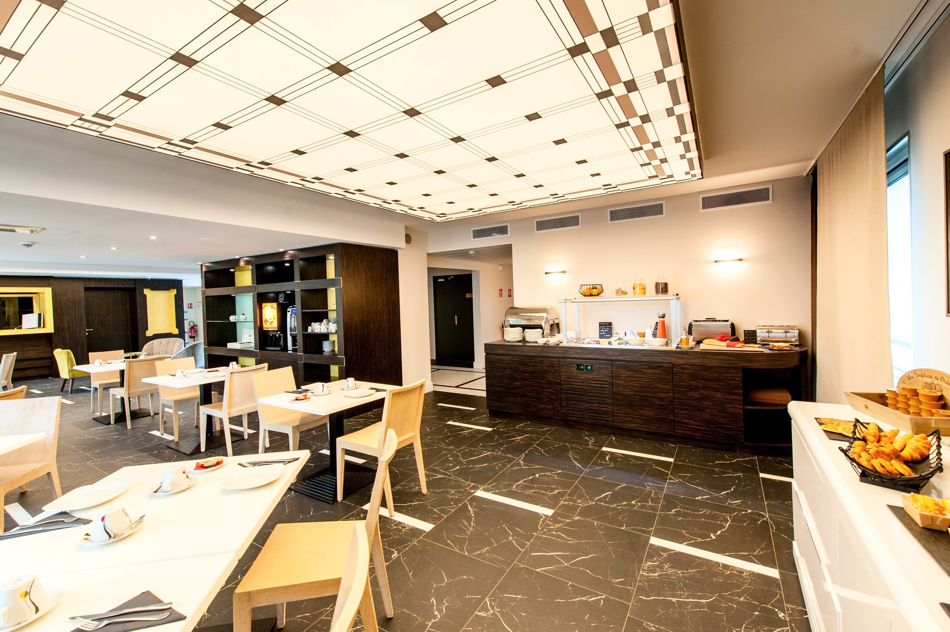 A modern hotel lobby with a marble floor, a reception desk, and a buffet area.