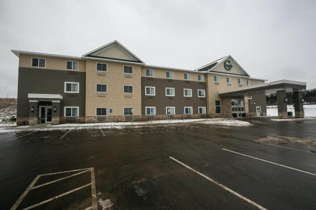 A multi-story hotel with a parking lot in front.