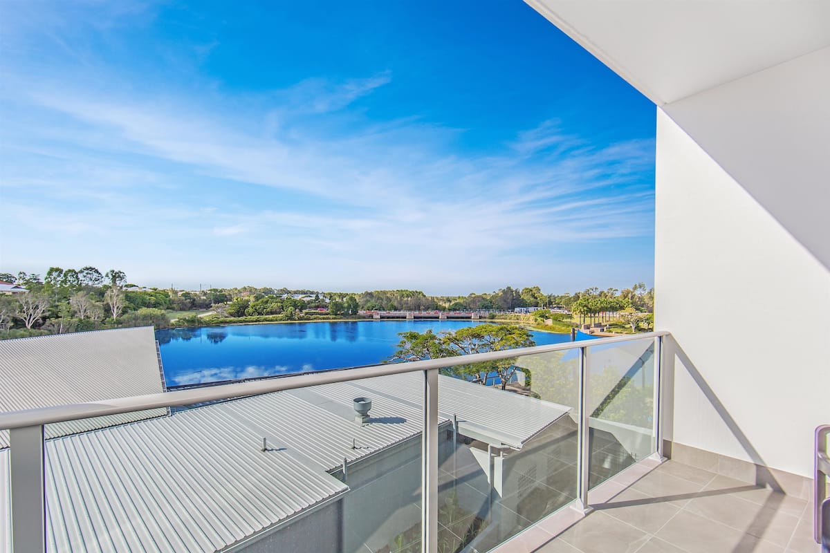Un balcon donnant sur une piscine et la végétation environnante.