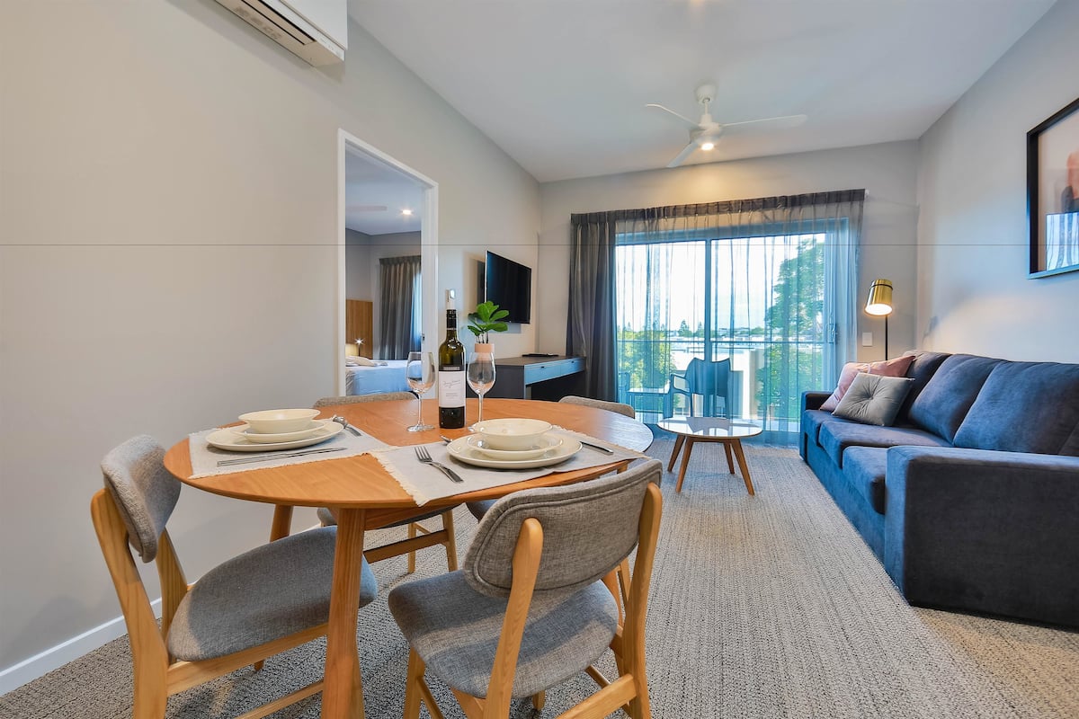 Un salon moderne comprenant un coin repas, un canapé et un balcon avec vue.